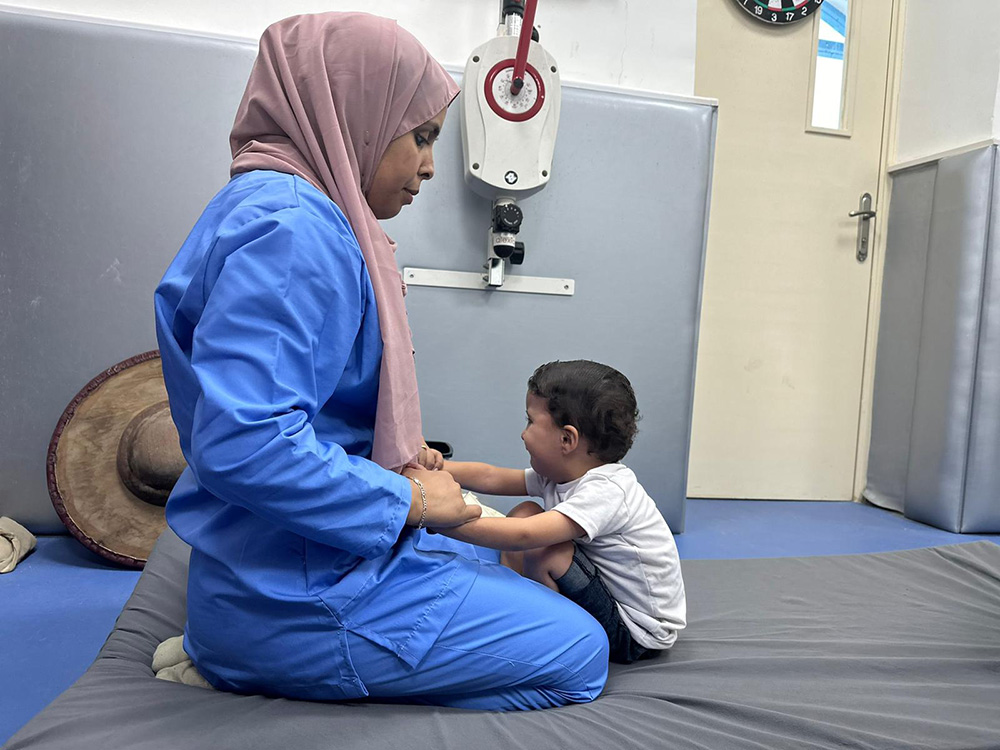 A staff member of Al Ahli Hospital provides comfort to a traumatised child. © Diocese of Jerusalem. Used with permission.