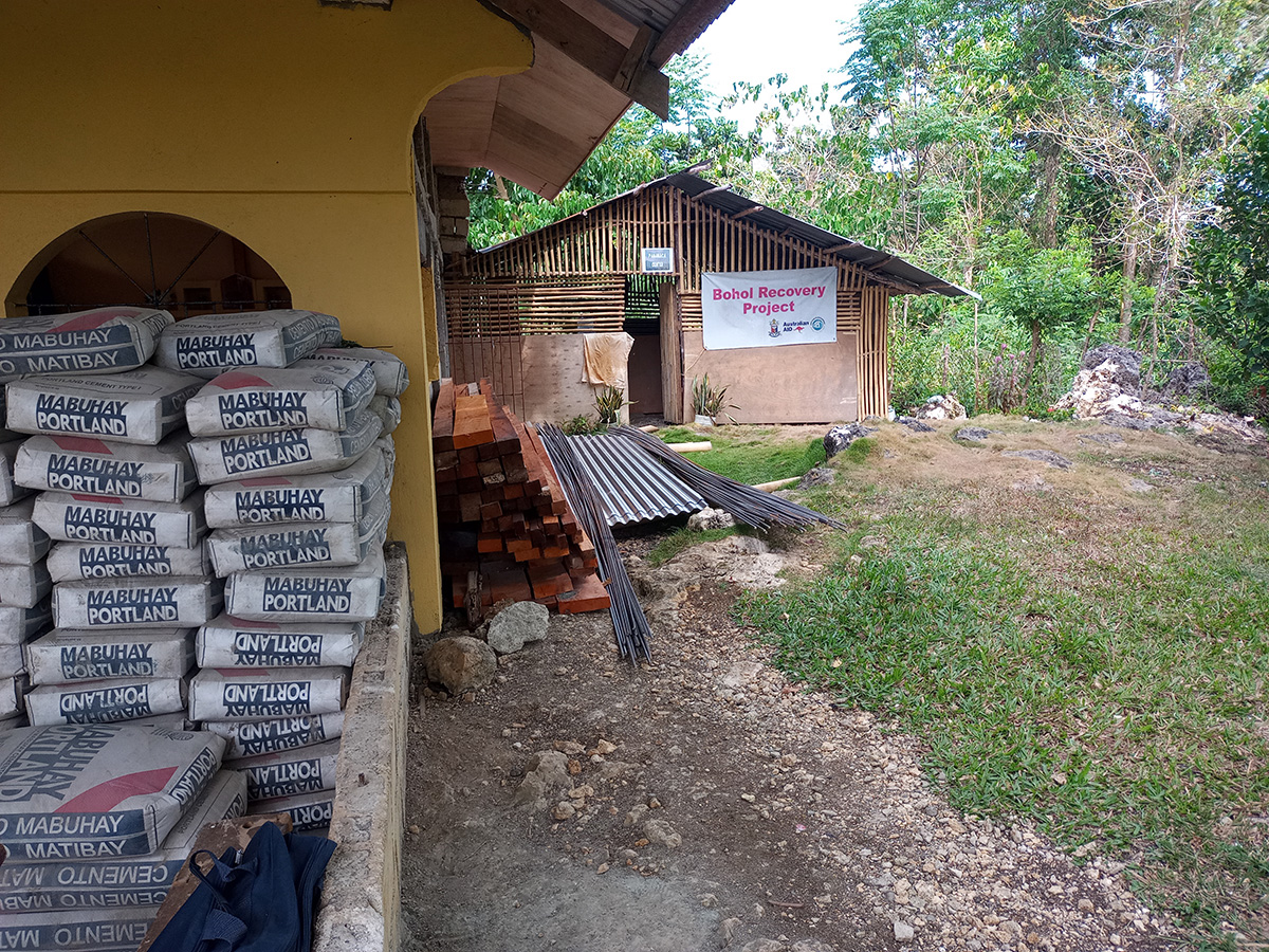 PAMAMACA’s bamboo store room (background) will soon be upgraded, using cement and timber (foreground) provided by the local government. © Terry Russell/ABM AID.