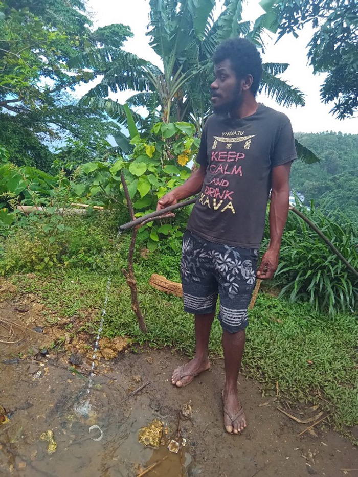 Brown helps repair an existing gravity-fed water system in rural Vanuatu. (C) ACOM-V. Used with permission.