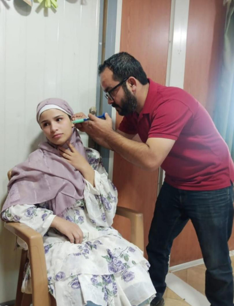 A hearing technician takes Anfal’s earmold measurement. © Holy Land Institute for the Deaf. Used with permission.