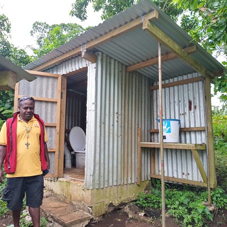 Fr Haggai in Tanbok, Penama Province, Vanuatu with an improved toilet from a previous stage of the church’s WASH program. © ACOM-V. Used with permission.