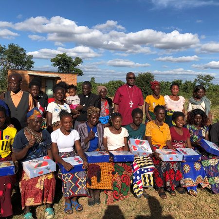 Leaders of the Savings with Education groups receive their group cash boxes. © Julianne Stewart/ABM.