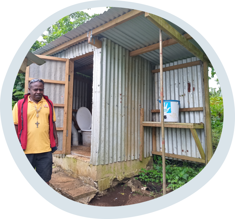 Fr Haggai in Tanbok, Penama Province, Vanuatu with an improved toilet from a previous stage of the church’s WASH program. © ACOM-V. Used with permission.