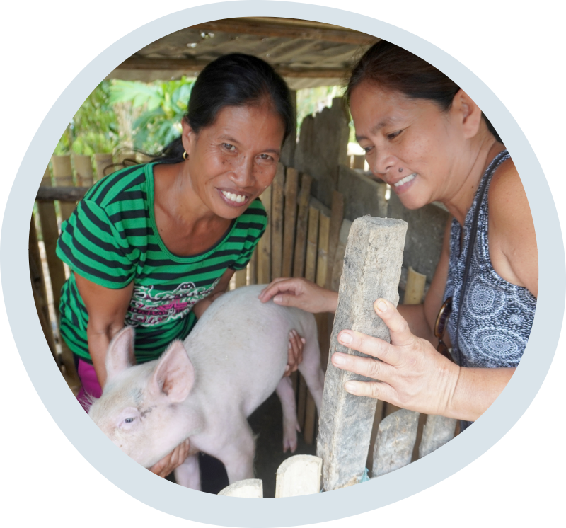 Oliva and Esmerelda with a happy and healthy piglet raised using the LEISA method. © IFI-VIMROD. Used with permission.